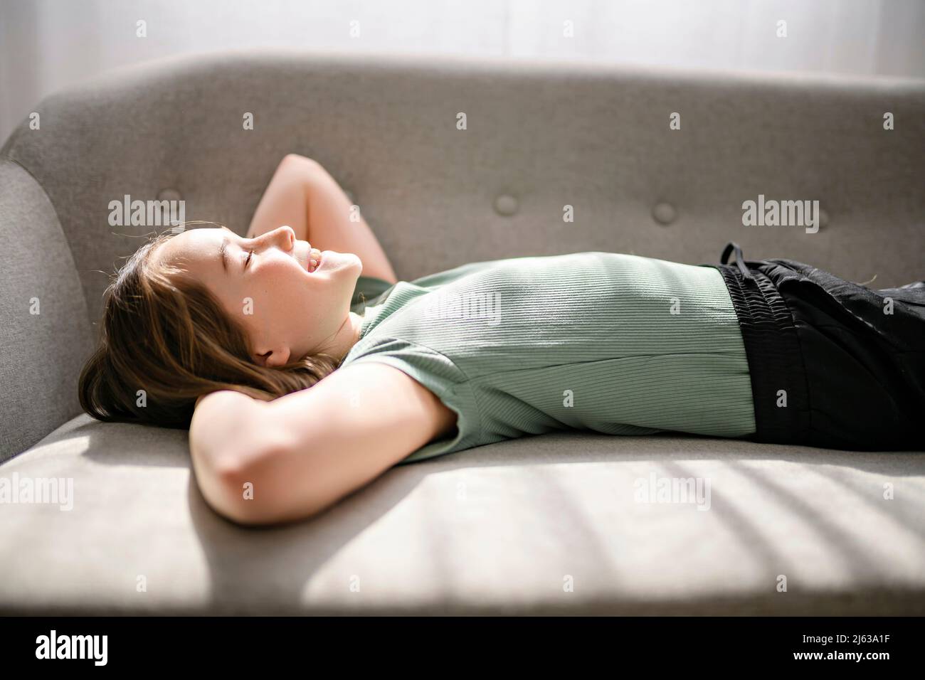 Beautiful pre teen girl lay on the sofa at home Stock Photo Alamy