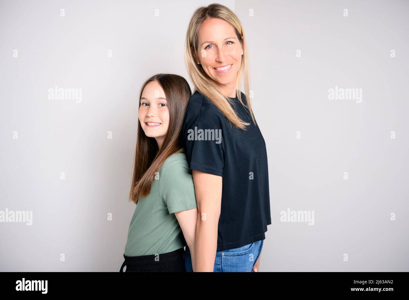 Beautiful pre teen girl with mother on studio white background Stock Photo