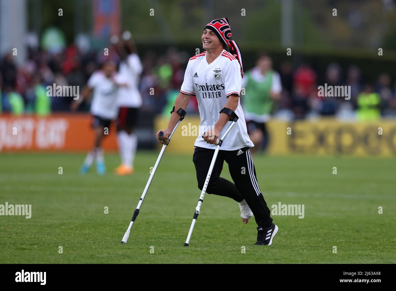 Nyon, Switzerland, 25th April 2022. Joao Neves of SL Benfica hops across the pitch on his crutches to celebrate with team mate Andre Gomes following the final whistle of UEFA Youth League match at Colovray Sports Centre, Nyon. Picture credit should read: Jonathan Moscrop / Sportimage Stock Photo