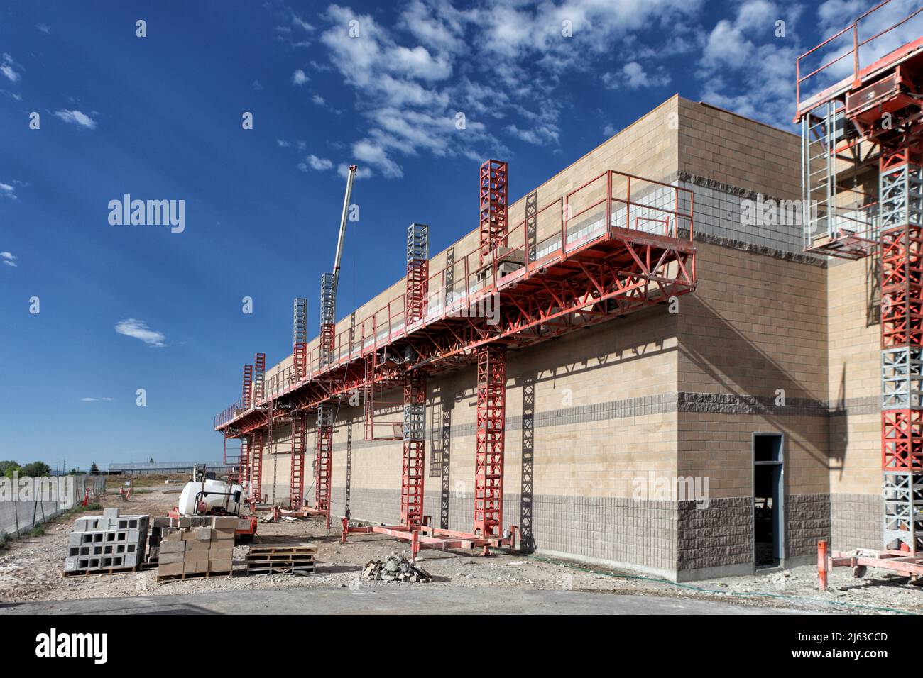 Masonry scaffolding around a concrete block building under construction. Stock Photo