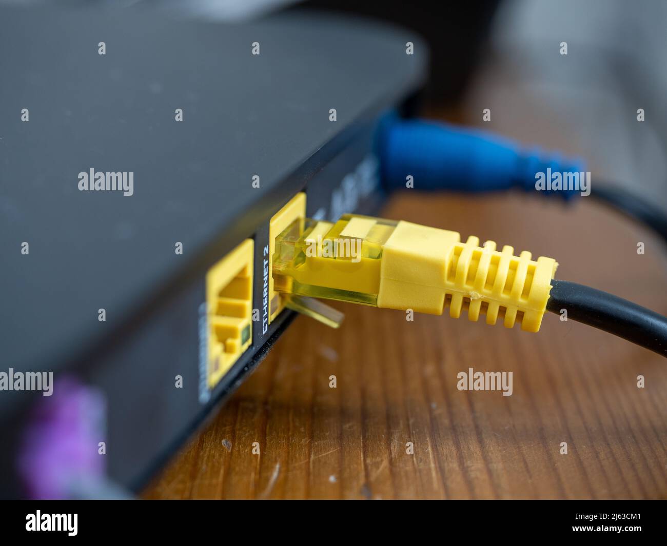 Close up of an yellow Ethernet connection to a broadband wireless router for high speed data transfers Stock Photo