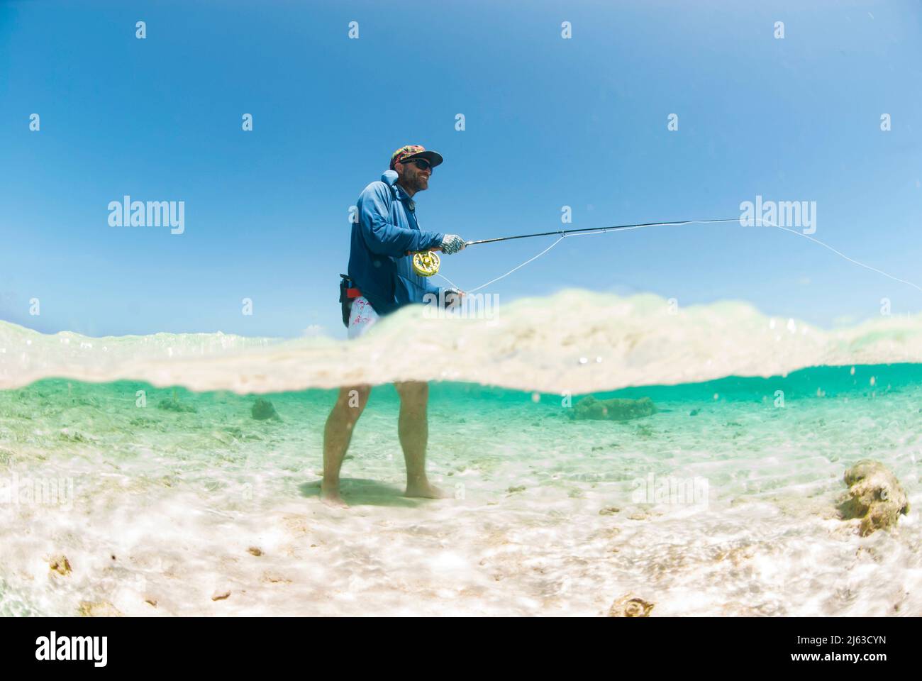 Half above and half below image of Fly fisherman casting Stock Photo