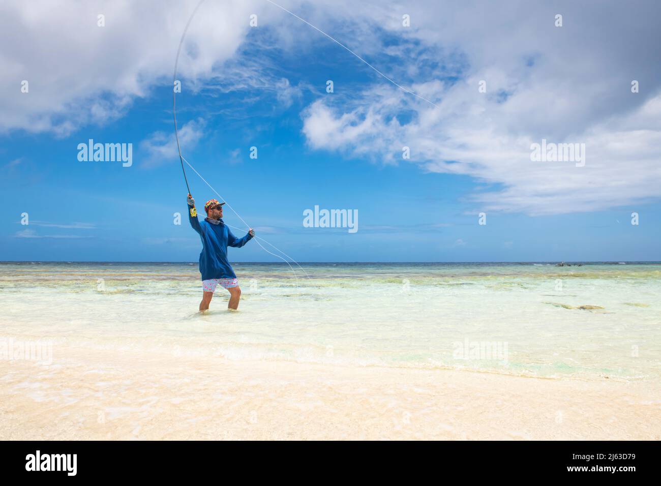 Fisherman casting in Caribbean clear waters Stock Photo