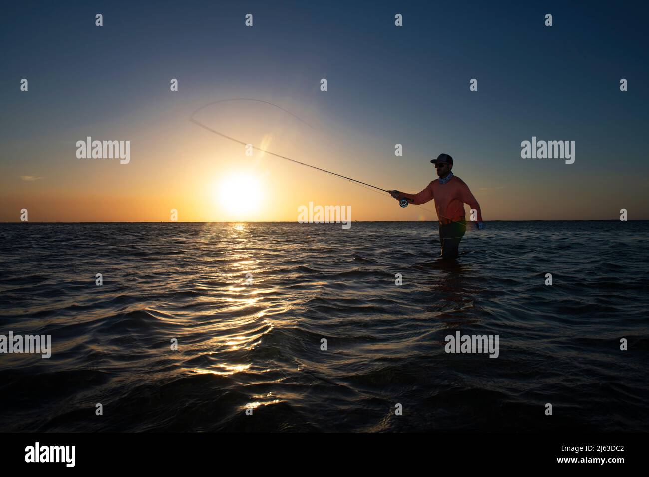 Your man Fly fishing at sunset in the Caribbean Stock Photo