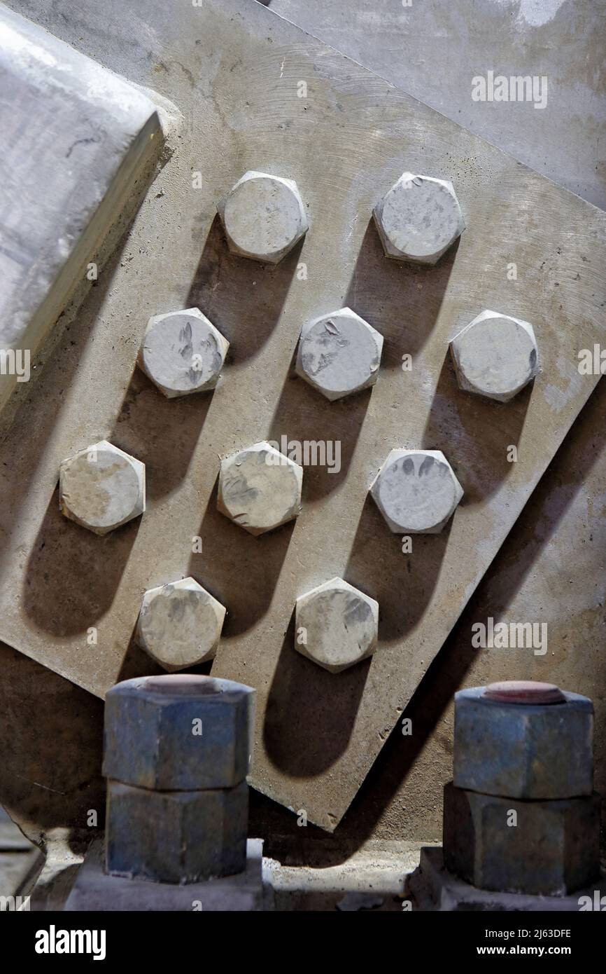 A joining plate anchor in an industrial framing application, with 10 bolts evenly spaced and torqued to the same amount to prevent slippage. Stock Photo