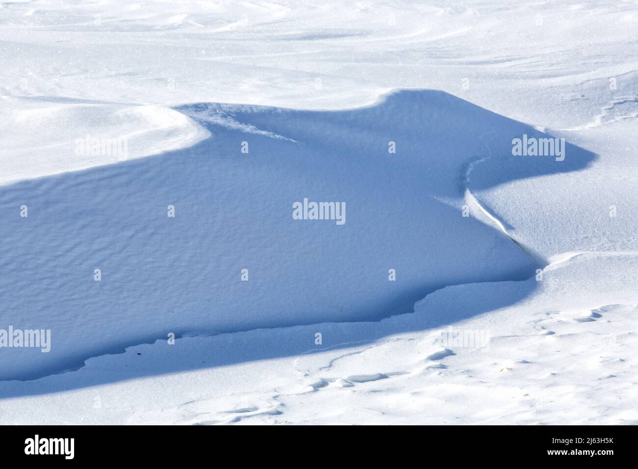 Patterns and textures in a snowy field, caused by blowing wind, and drifting snow. Stock Photo