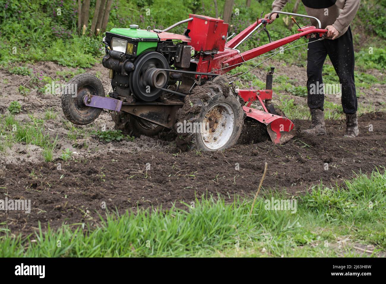 Man farmer working in field ploughing land with plough on farm. Season processing soil in village. Organic cultivate natural products. Agriculture Stock Photo