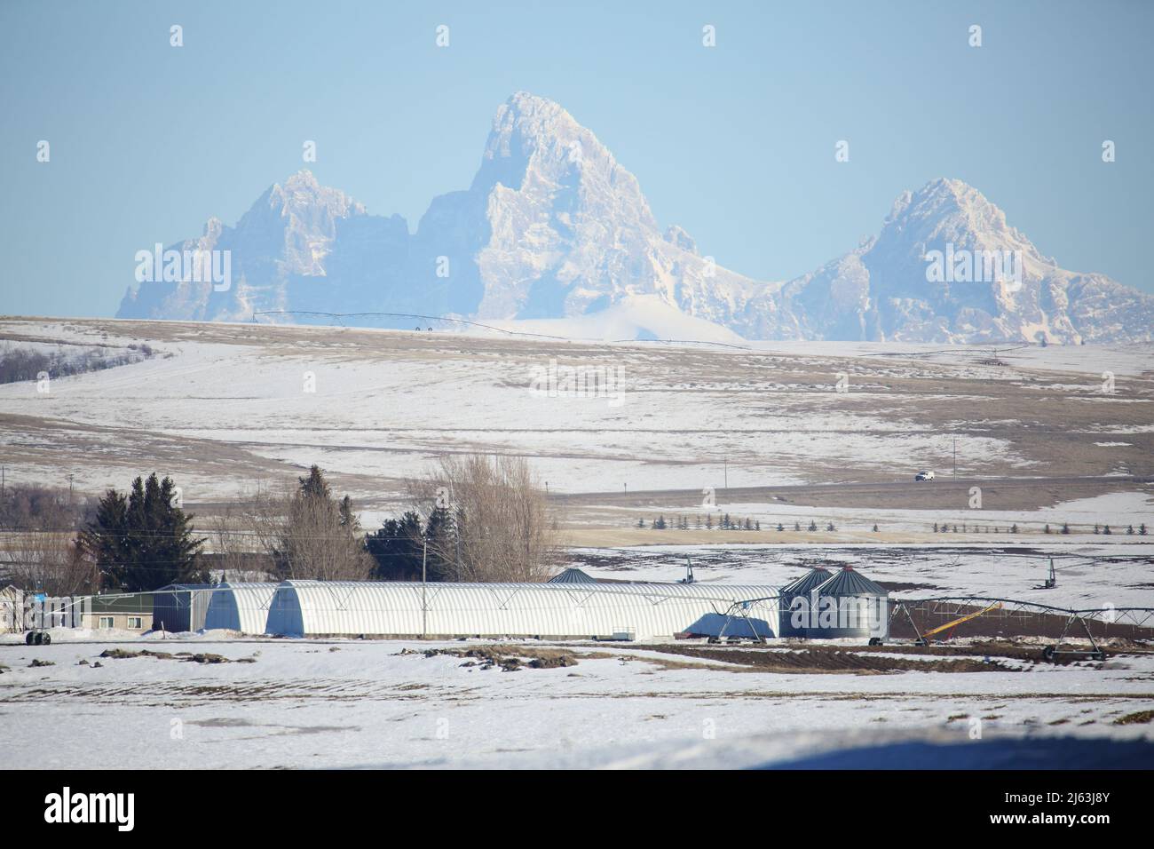 Farmland and farm buildings in front of the Teton mountain range in Idaho. Stock Photo