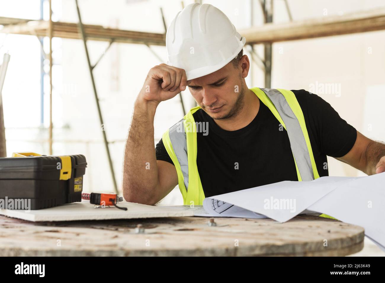 Worker is checking blueprints during his work on a construction site Stock Photo