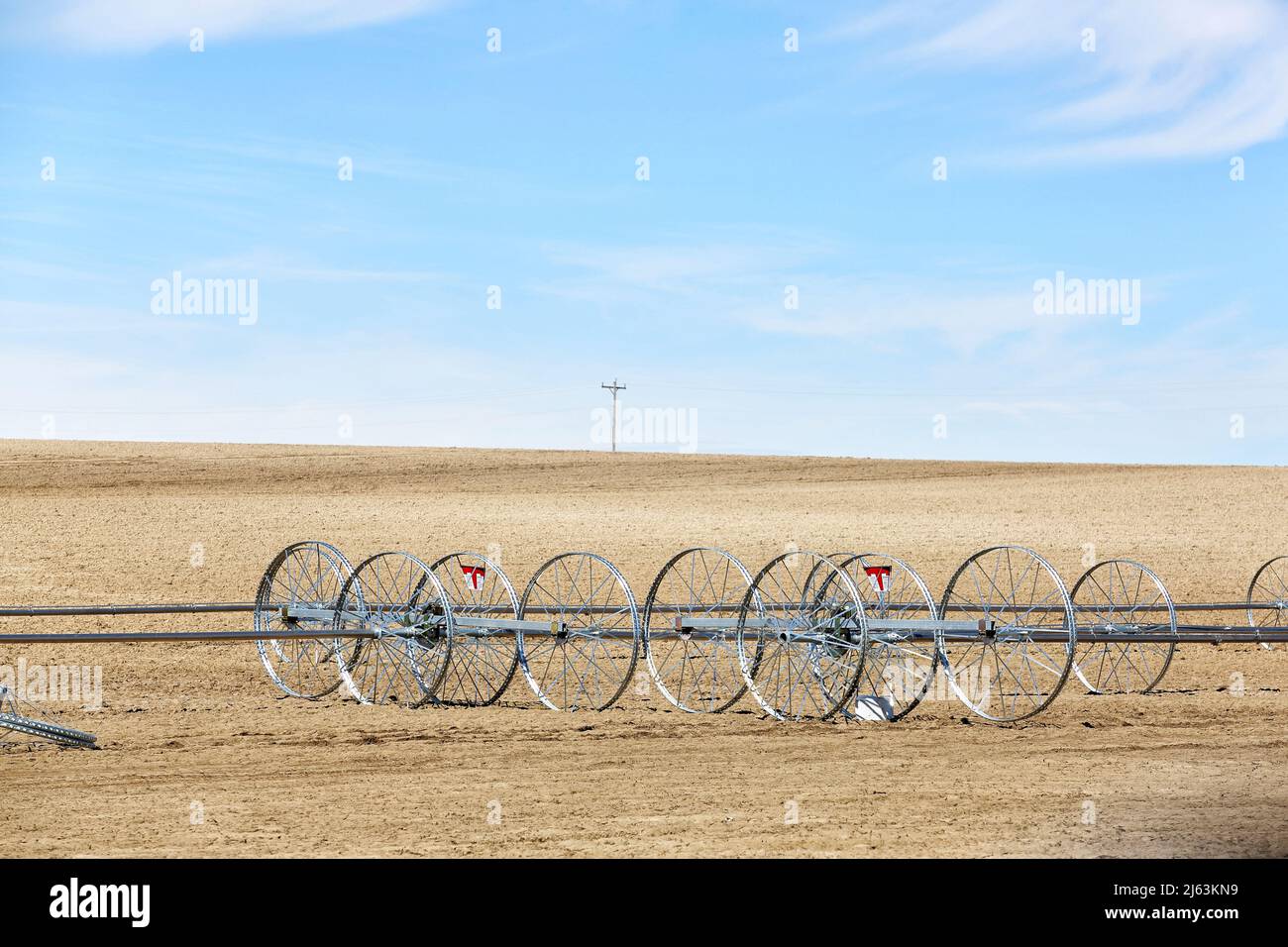 A newly set up wheel line sprinkler ready to irrigate a wheat field, in the fertile farm fields of Idaho. Stock Photo