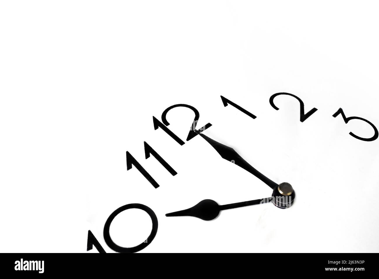 The image of a clock close up. Clock hands black and red. Close up of