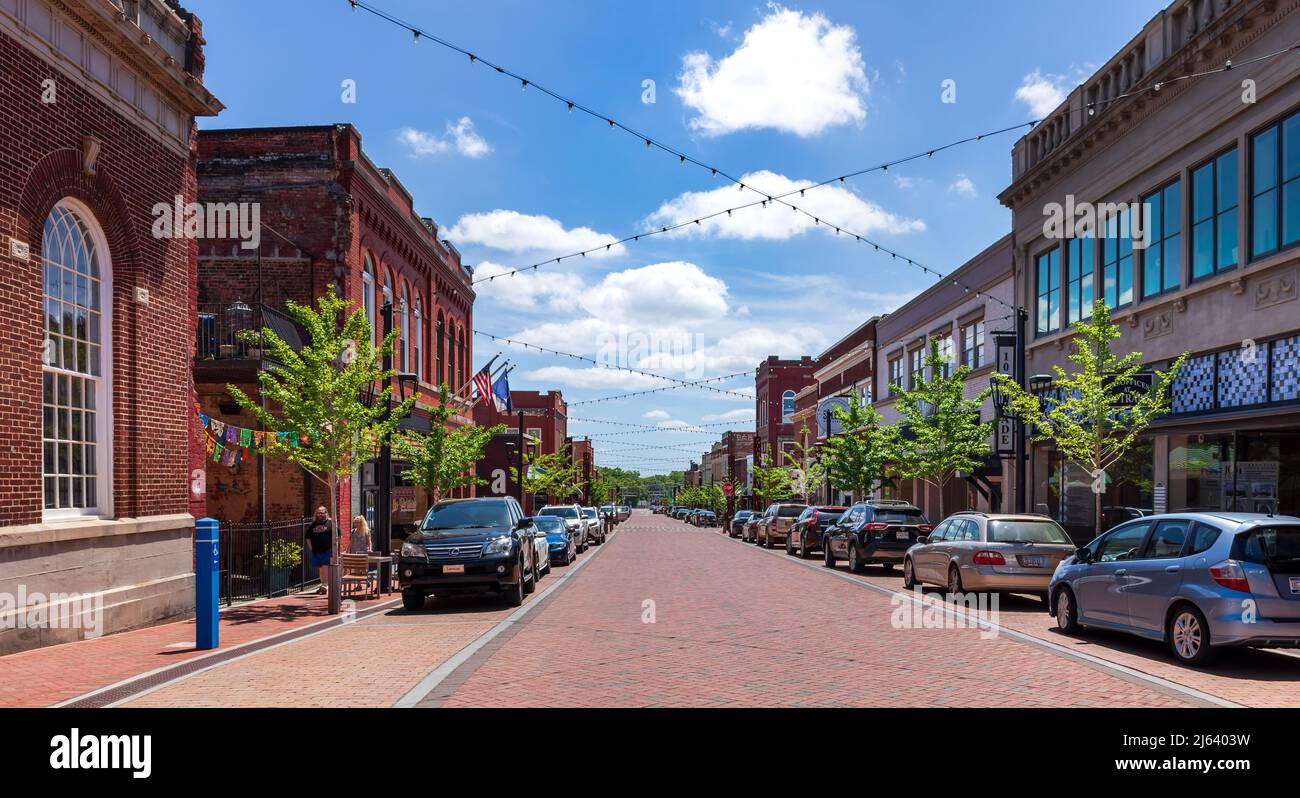 GREER, SC, USA 24 APRIL 2022: Wide angle perspective view down Trade Street on sunny, spring day.  Two people walking. Stock Photo
