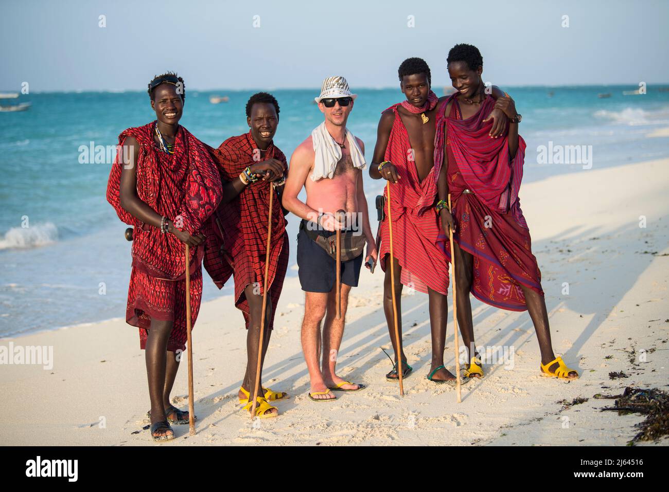Zanzibar, Tanzania - January 02,2019: Masai warriors dressed in traditional clothes on sand beach of Zanzibar island. Stock Photo