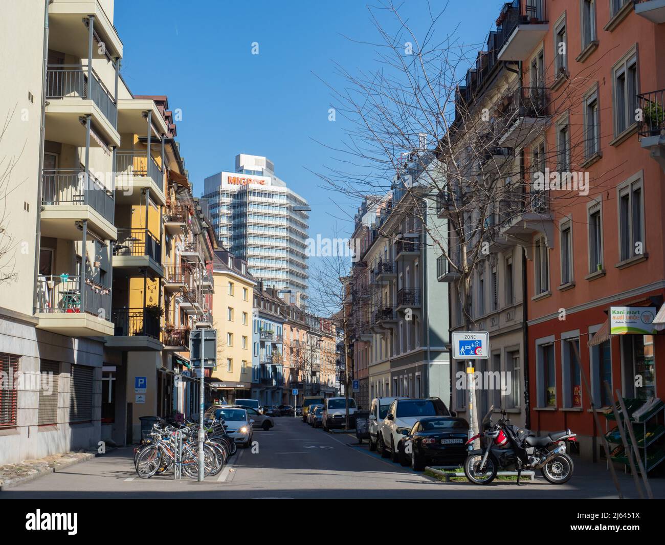 Zurich, Switzerland - March 5th 2022: View along a residential street towards a modern business tower. Stock Photo