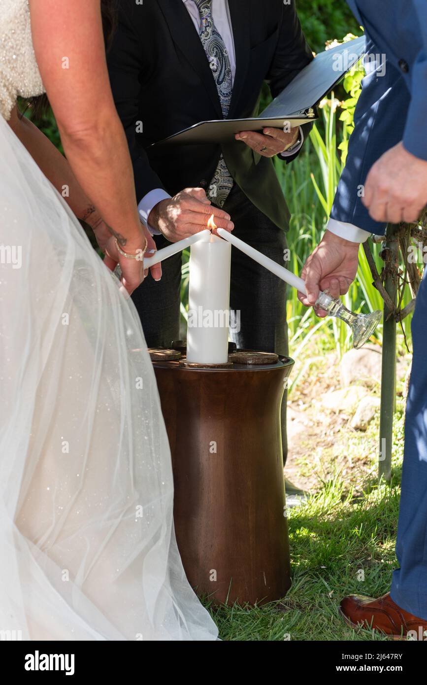Bride and groom taking their individual candles and lighting the larger