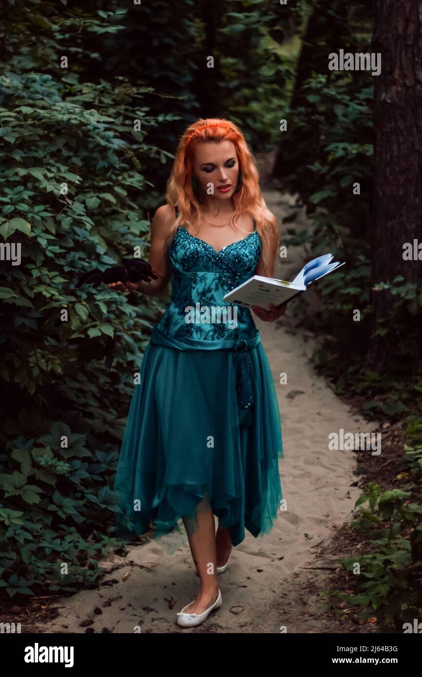 A young beautiful woman with red hair reads a book in the woods Stock ...