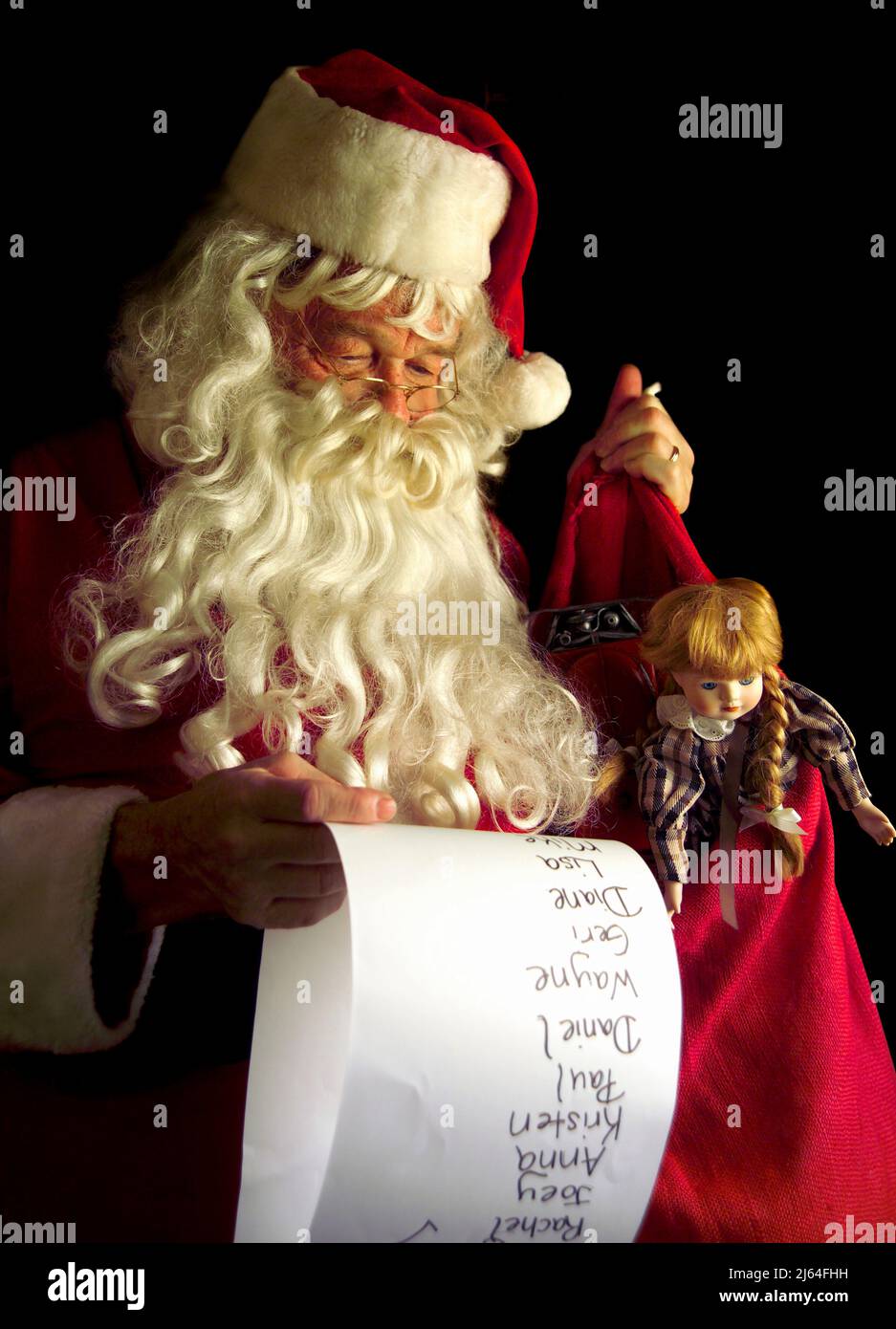 Santa Claus holding his bag of toys while checking his list of good children. Stock Photo