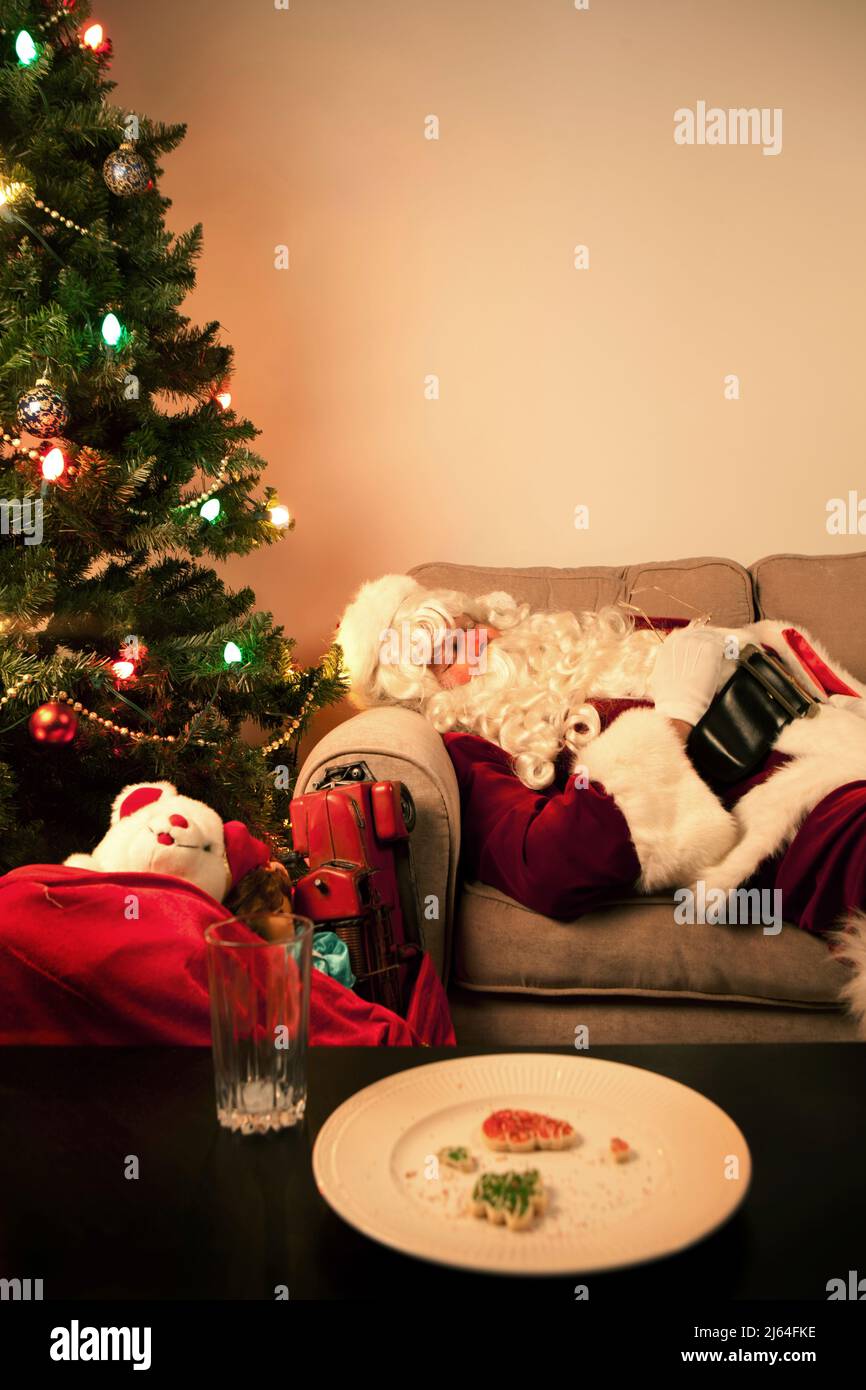 Santa Claus taking a nap while delivering toys on Christmas Eve. Stock Photo