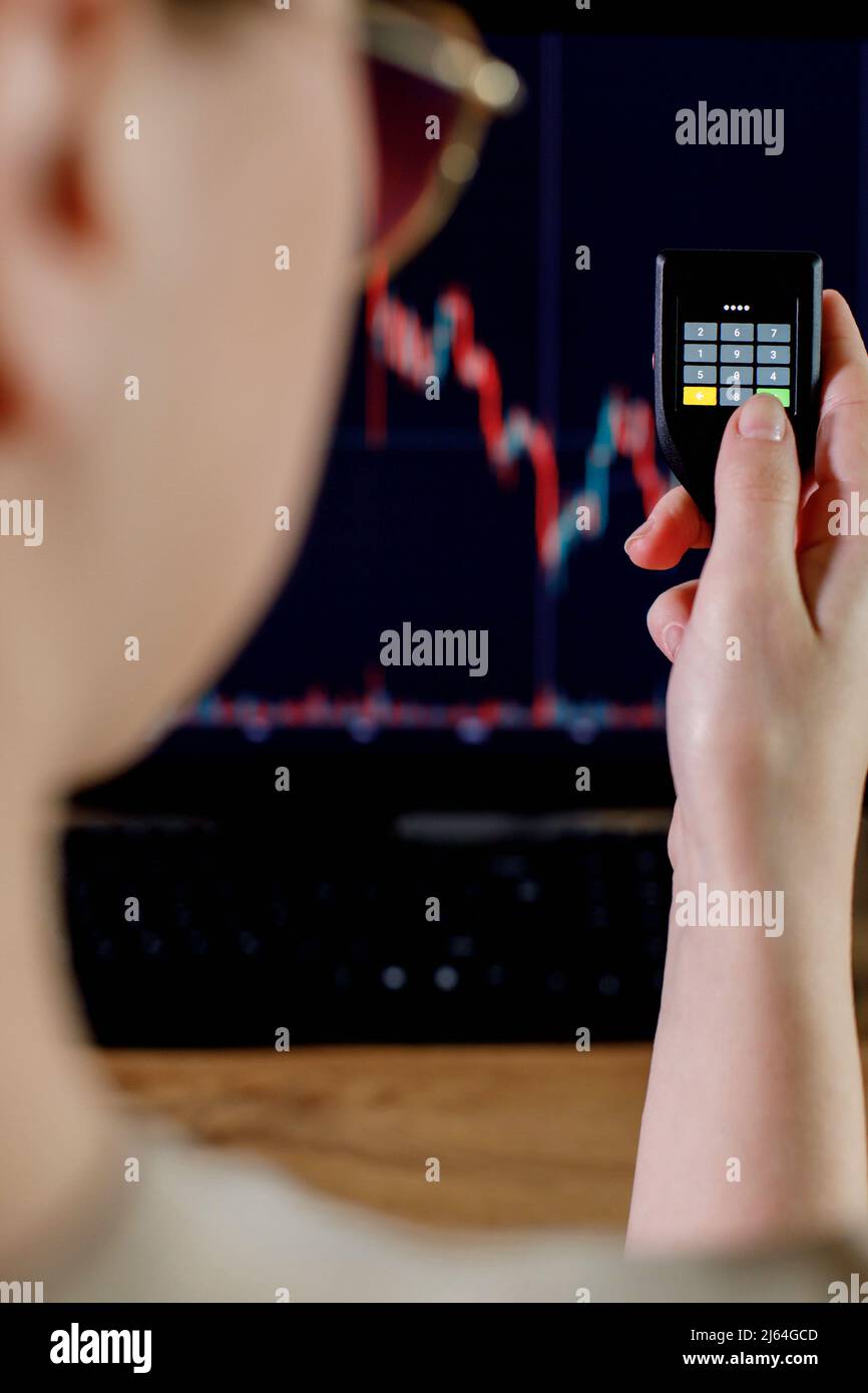 Business woman trader investor analyst using cryptocurrencey hardware cold  wallet on background with stock market graph on the screen. Secure  cryptocurrency storage Stock Photo - Alamy