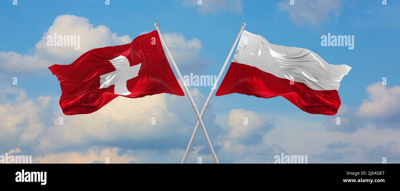 two crossed flags switzerland and Poland waving in wind at cloudy sky ...