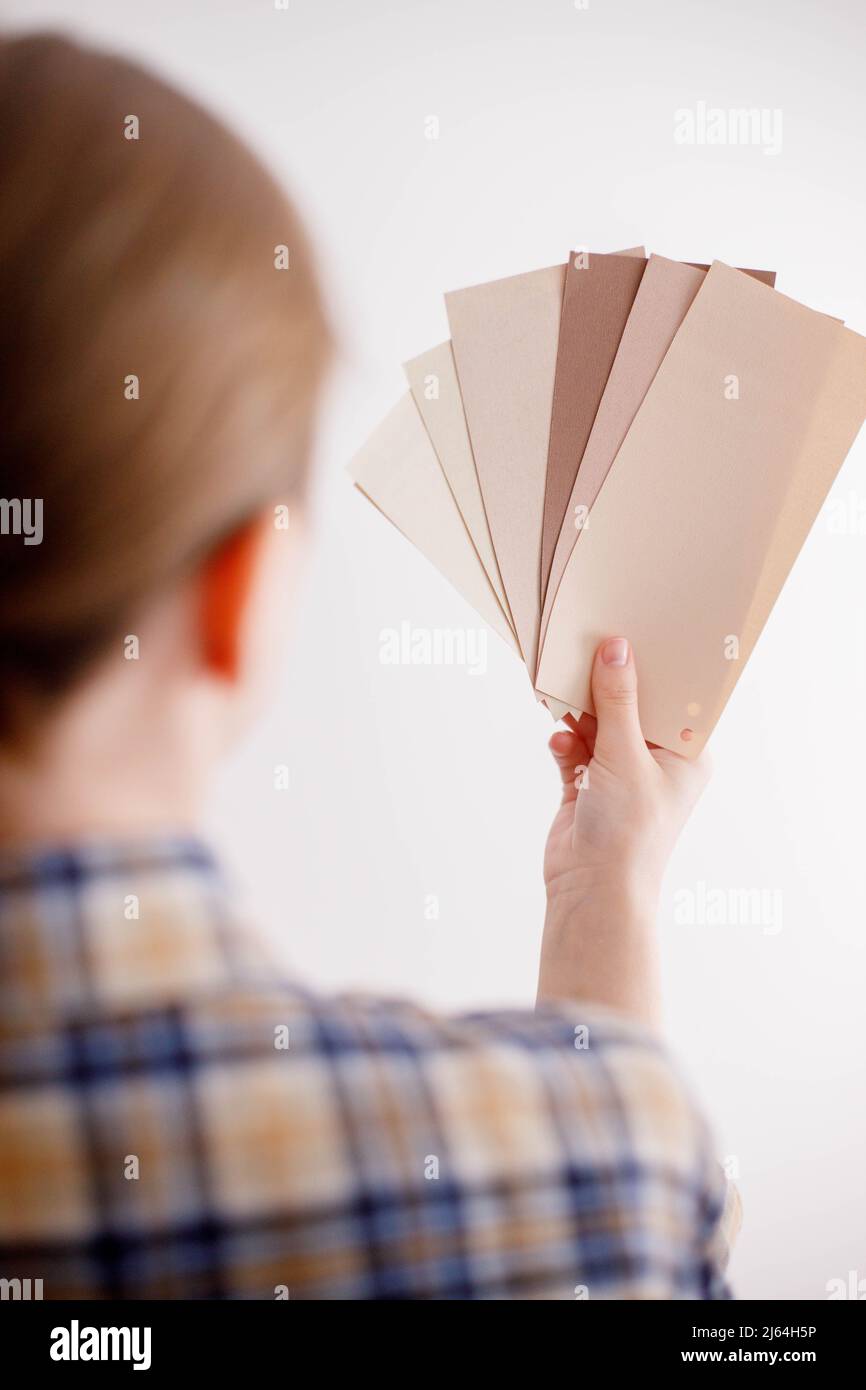 Young woman holds in her hand color paint samples for the wall Stock Photo