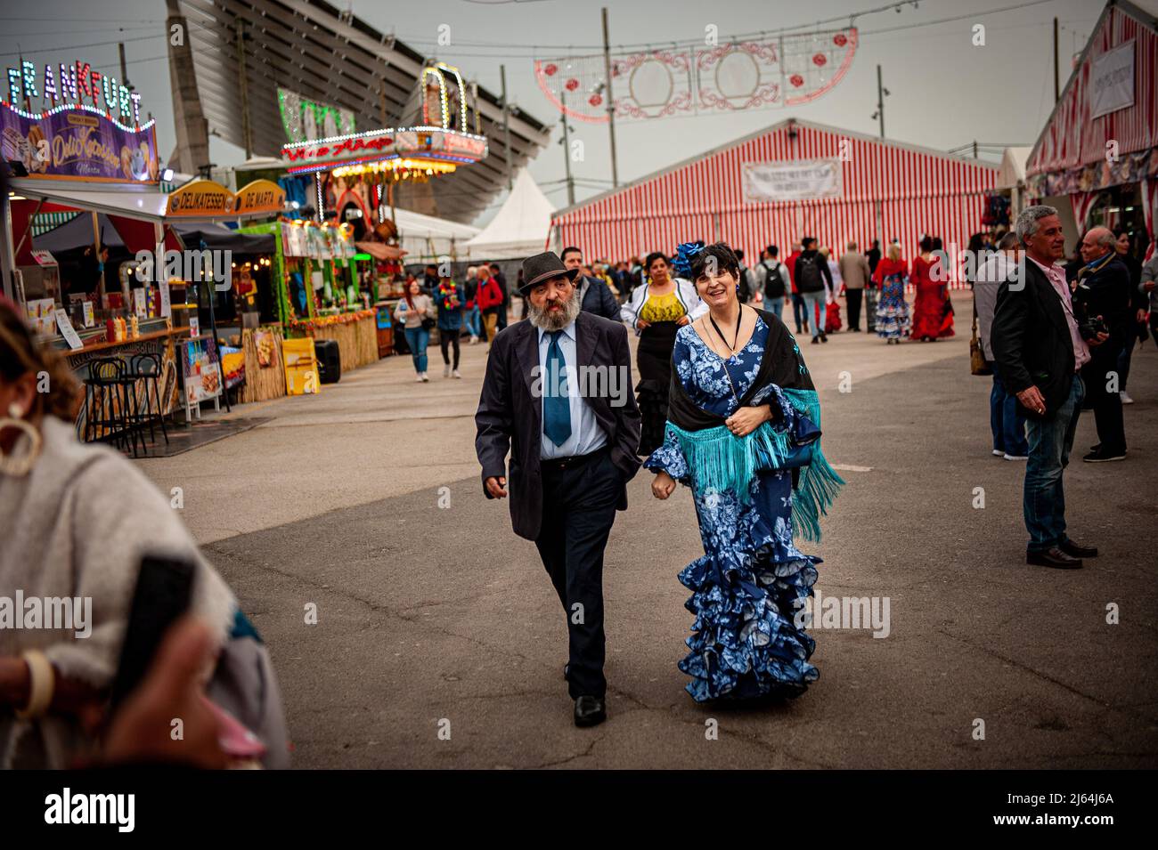 Barcelona, Spain. April 27, 2022, Barcelona, Spain:  A woman wearing in traditional Andalusian dress walks along La Feria de Abril (April Fair) held in Barcelona's Forum Park. The Feria de Abril in Barcelona is a folkloric festival of Andalusian roots that has been celebrated in Catalonia for almost 50 years. Credit: Jordi Boixareu/Alamy Live News Credit:  Jordi Boixareu/Alamy Live News Stock Photo
