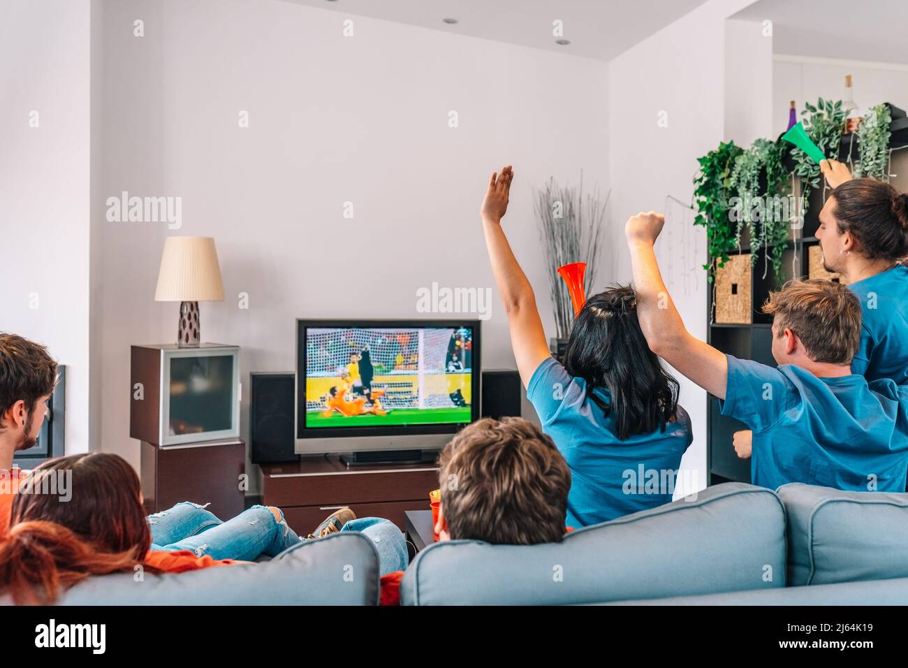 young friends celebrating their team's victory. young friends sad after their team's defeat. watching football on TV. Stock Photo