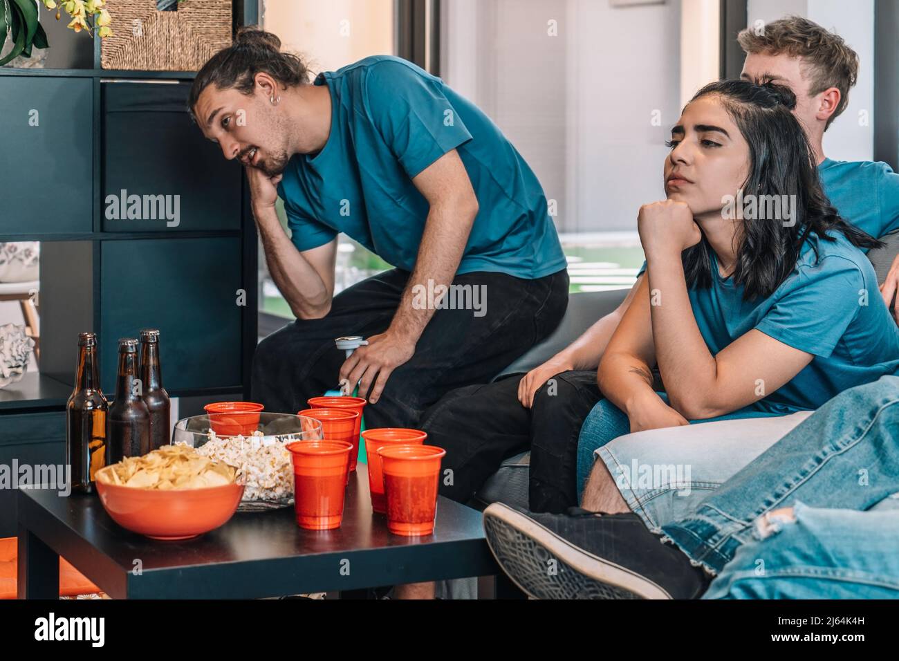 Football fans saddened by their team's defeat. Close-up of a table full of drinks and snacks for a party Stock Photo