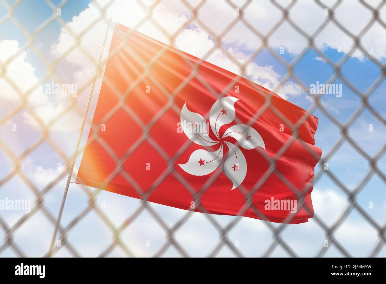A steel mesh against the background of a blue sky and a flagpole with the flag of hong kong Stock Photo