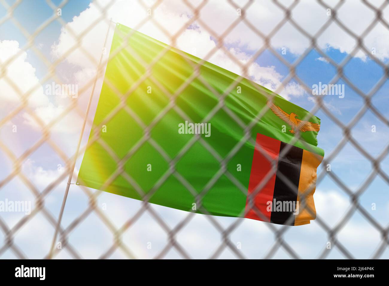 A steel mesh against the background of a blue sky and a flagpole with