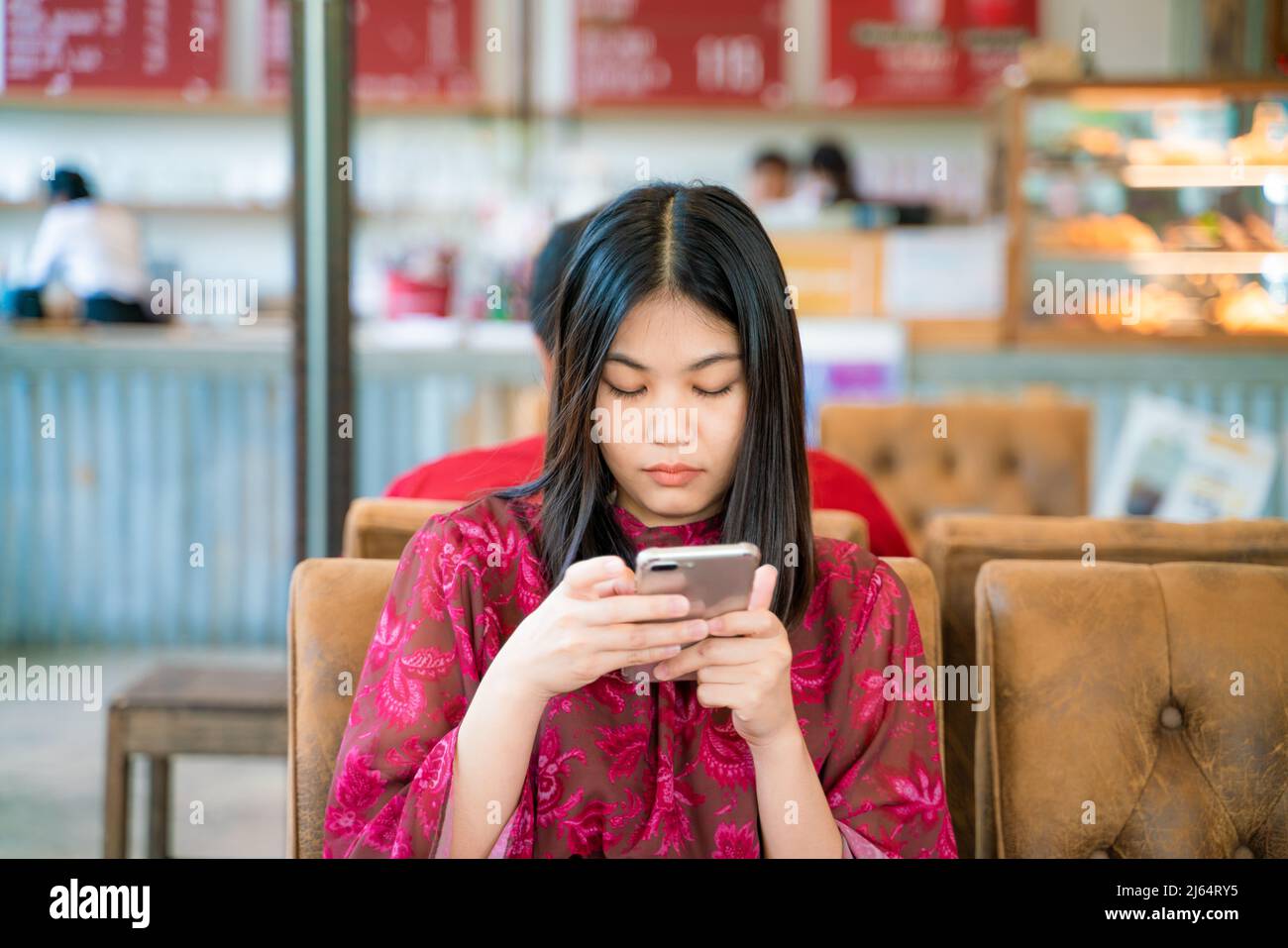 Beautiful asian women texting message on smartphone sitting in coffee ...