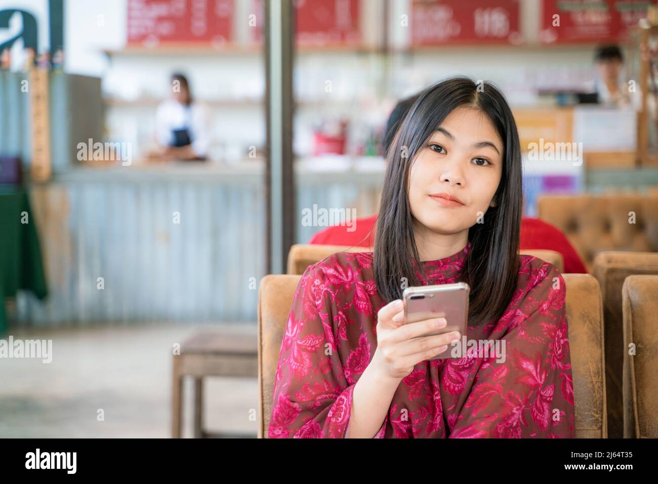Beautiful asian women texting message on smartphone sitting in coffee ...