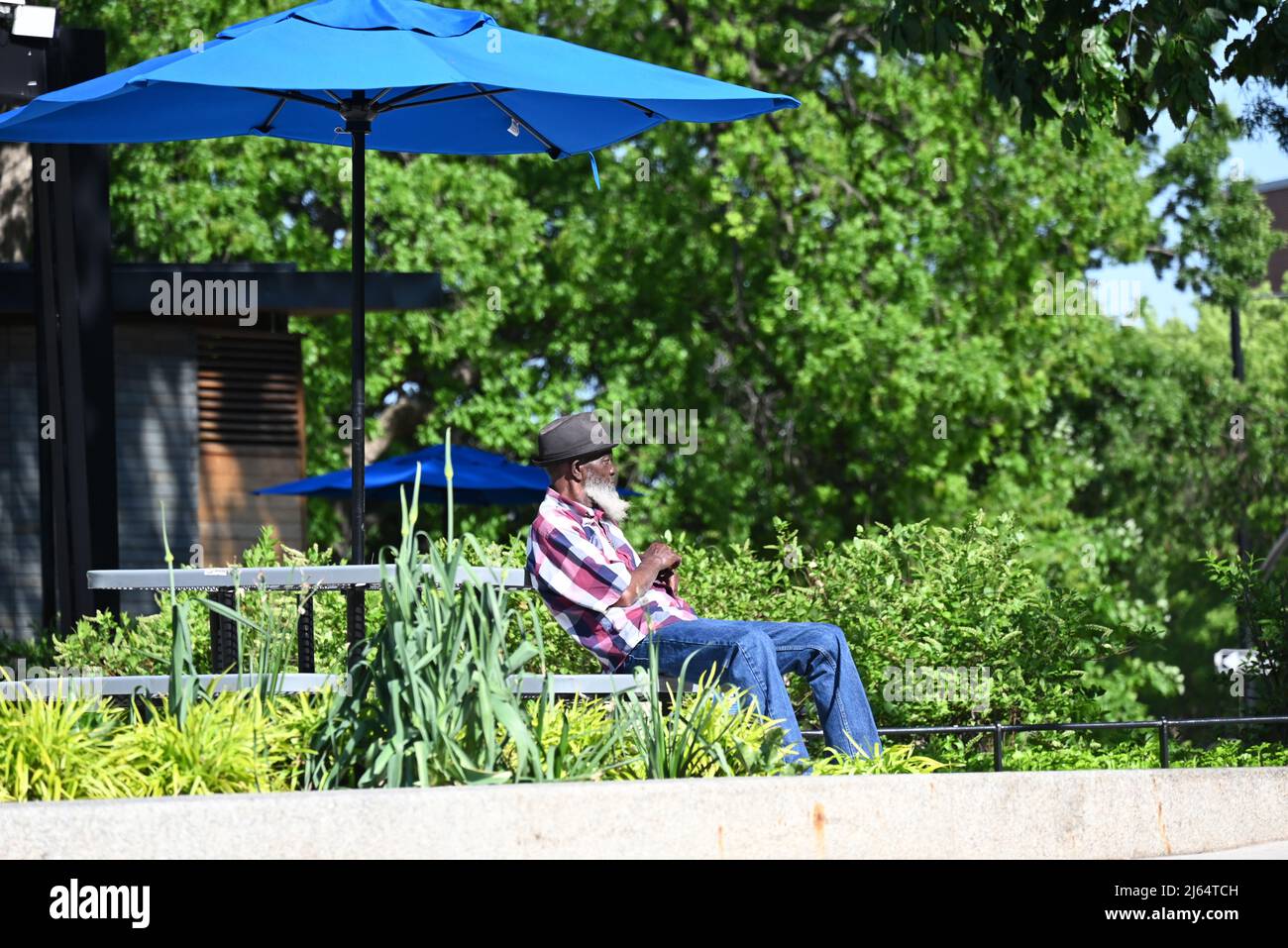 An older man sits at a table in Moore Square Park off downtown Raleigh, North Carolina. Stock Photo