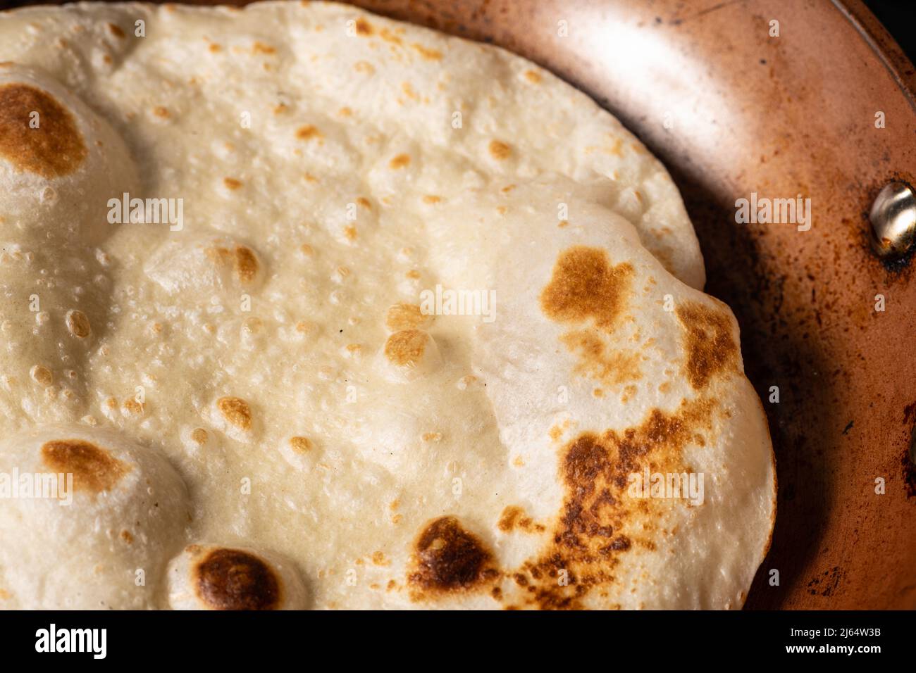 Cooking Tandoori Roti in frying pan, a typical flatbread and popular in