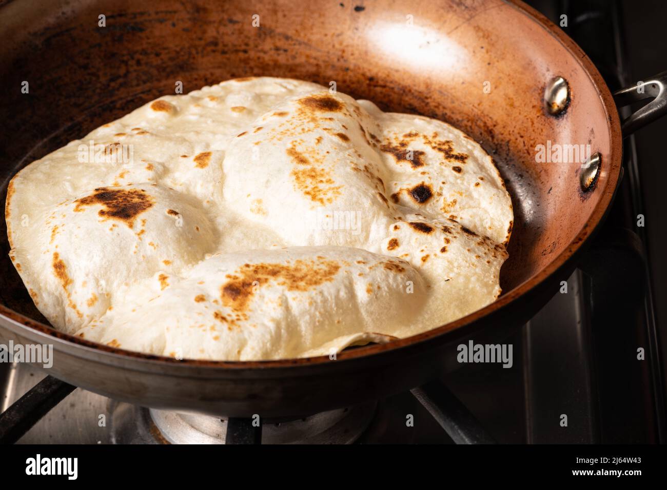 Cooking Tandoori Roti in frying pan, a typical flatbread and popular in
