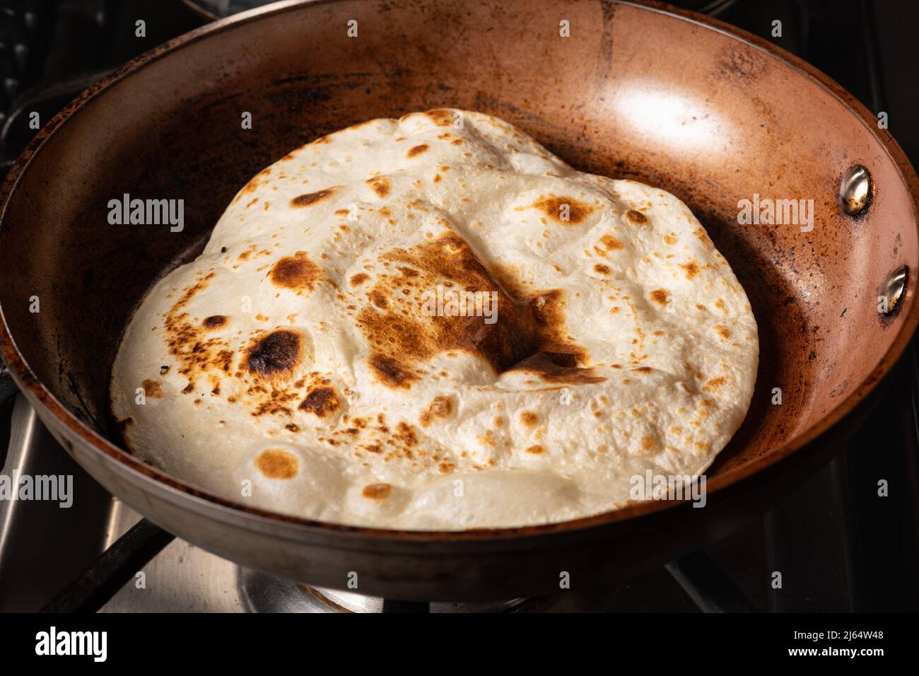 Cooking Tandoori Roti in frying pan, a typical flatbread and popular in