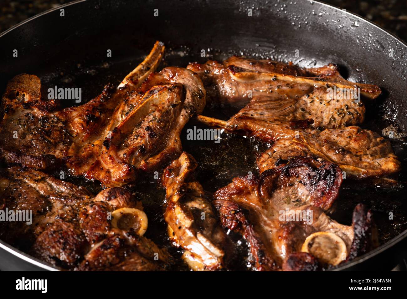 Cooking lamb loin chops in a frying pan. Cooking on a gas stove. Stock Photo