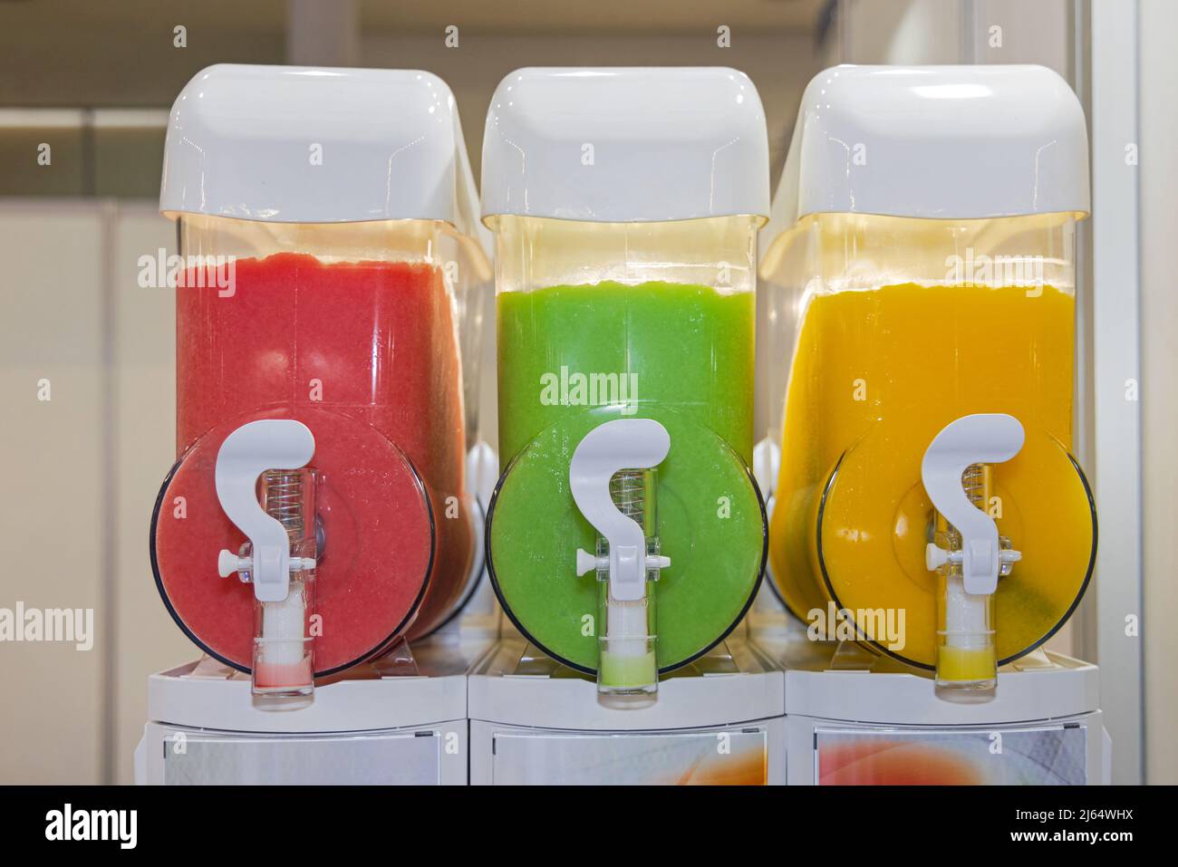 https://c8.alamy.com/comp/2J64WHX/three-colourful-soft-drinks-fruit-juice-dispenser-2J64WHX.jpg