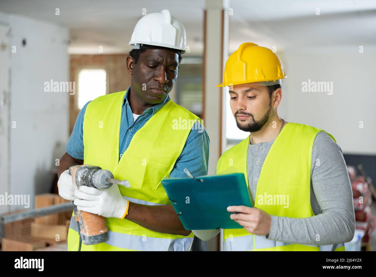 Two builders talking on indoor construction site Stock Photo
