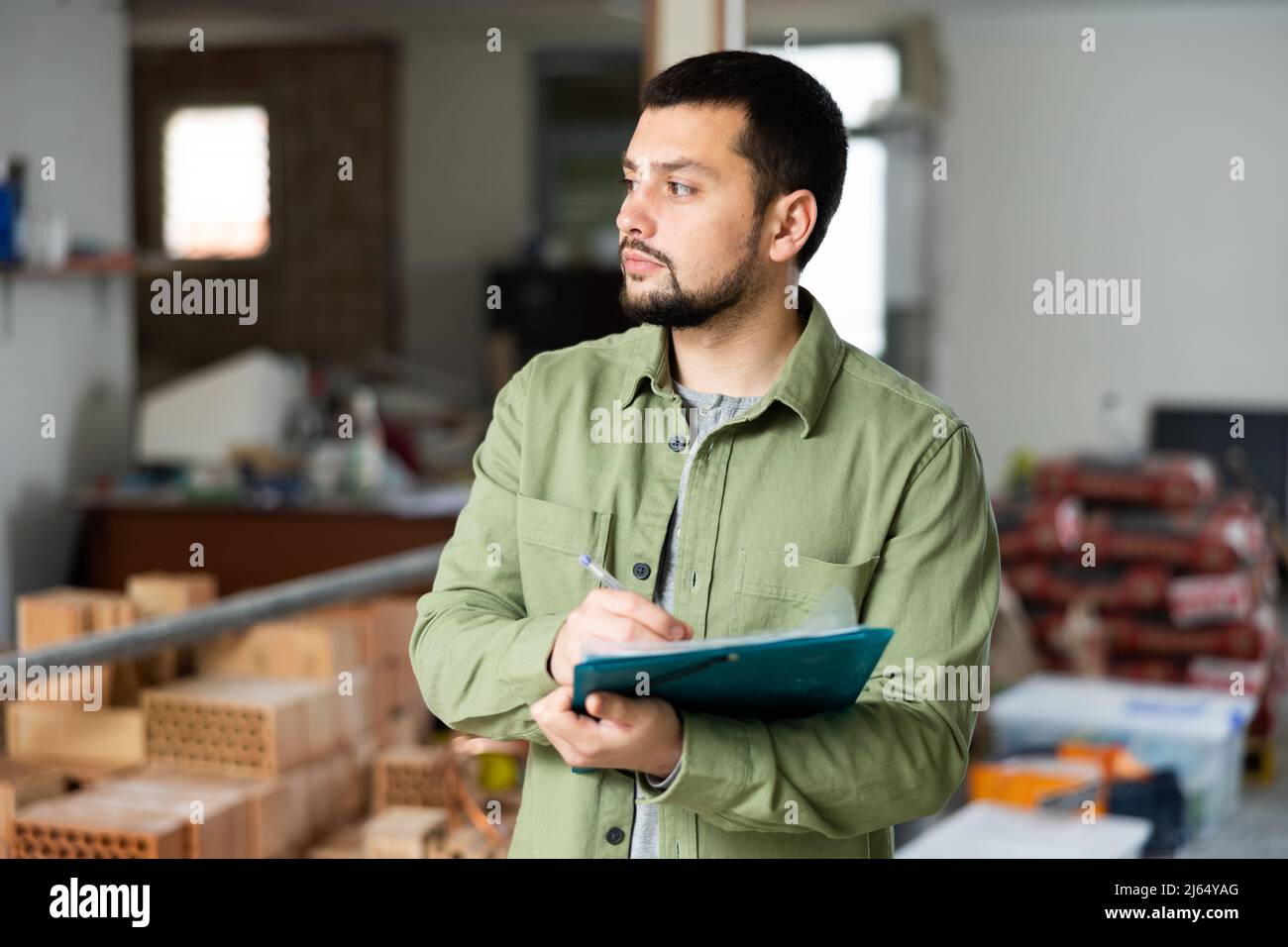 Architect making notes on indoor construction site Stock Photo - Alamy