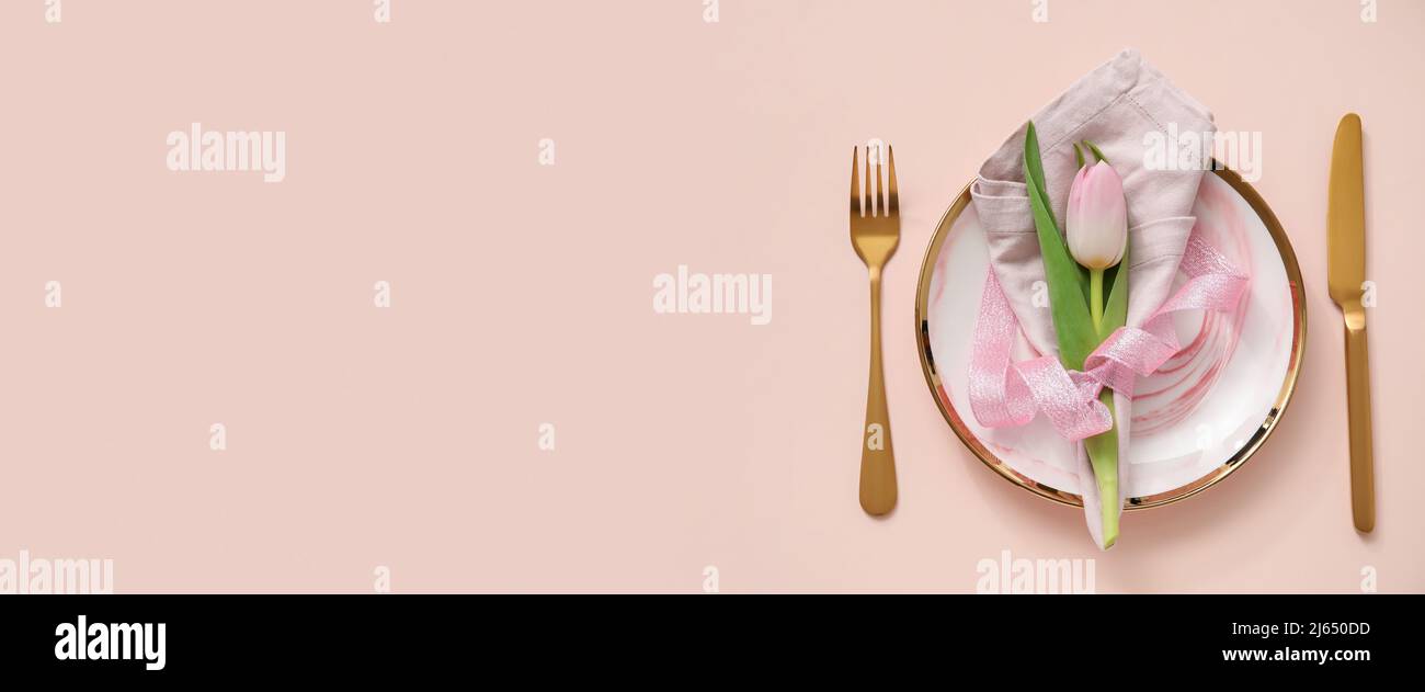 Simple spring table setting on pink background with space for text ...