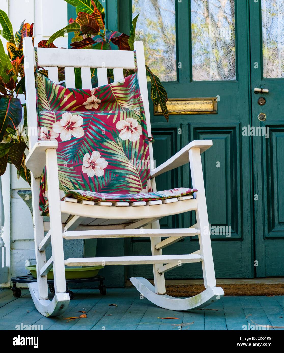 White rocking chair with colorful cushion on front porch of historic home in New Orleans, LA, USA on April 9, 2022 Stock Photo