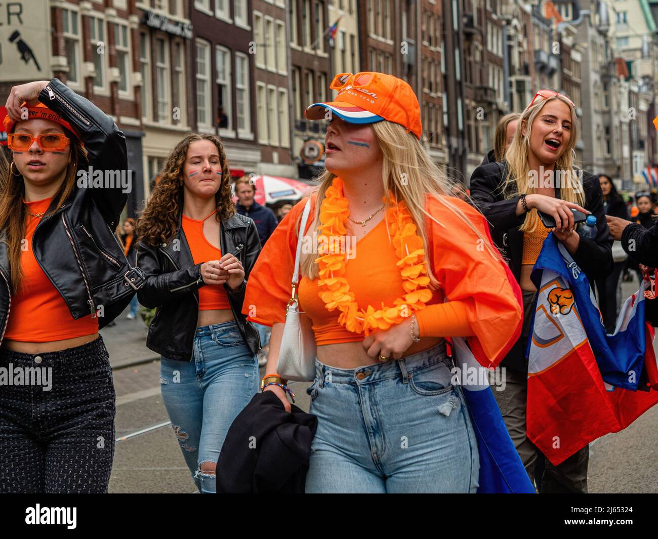 A group of women wearing orange clothes seen walking on the streets of the  city. After two years of restrictions, this year's King's Day celebrations  went back to normal. King's Day is