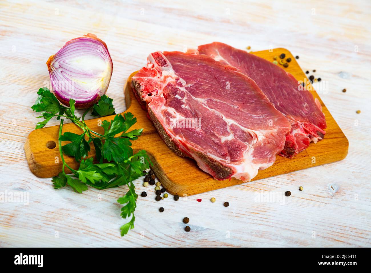 Sliced raw pork chop with parsley and onion Stock Photo Alamy