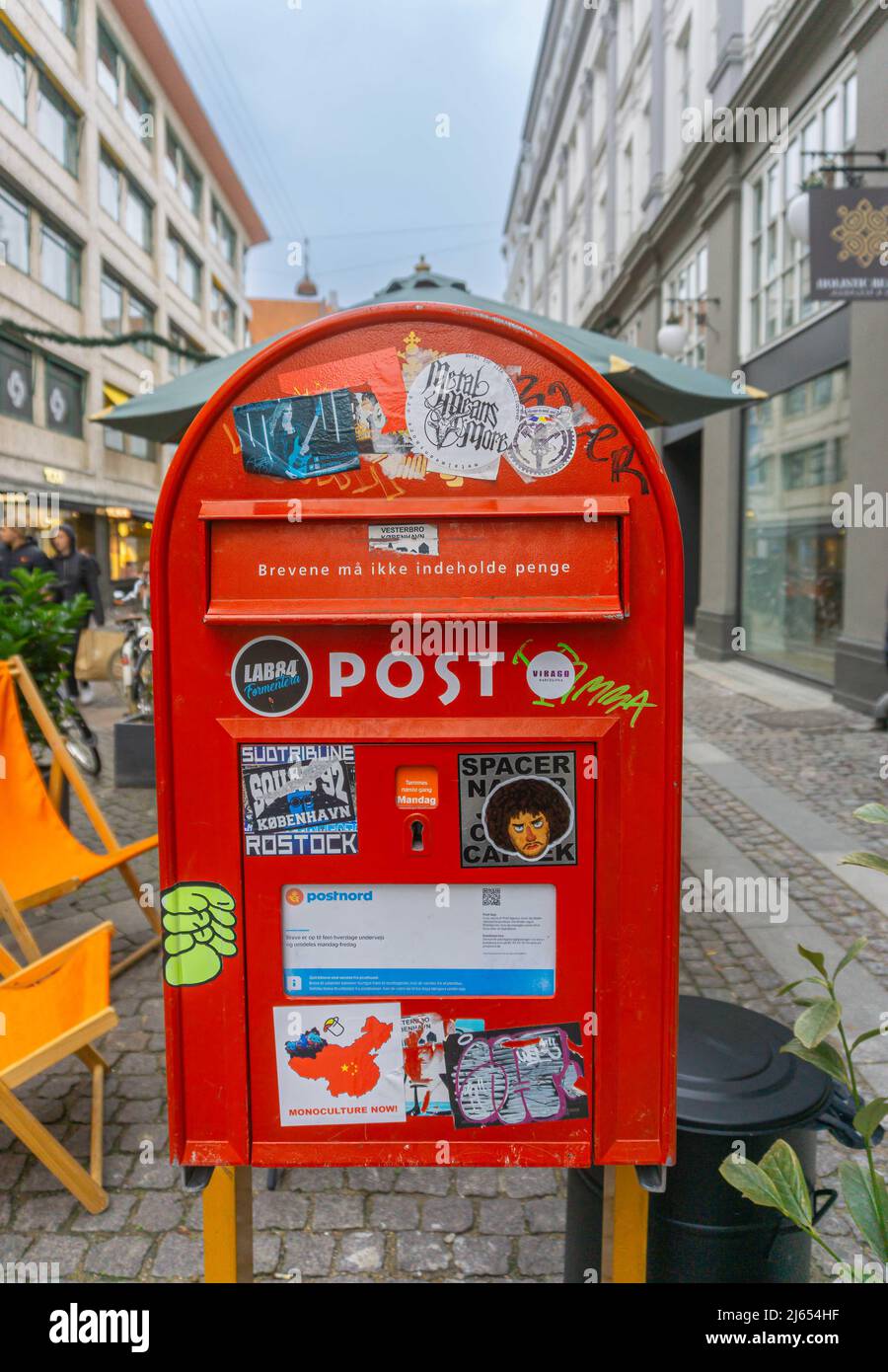 Copenhagen, Denmark - November 14, 2021: Red mailbox in the center of Copenhagen with many stickers and a text on the mailbox in Danish saying the let Stock Photo