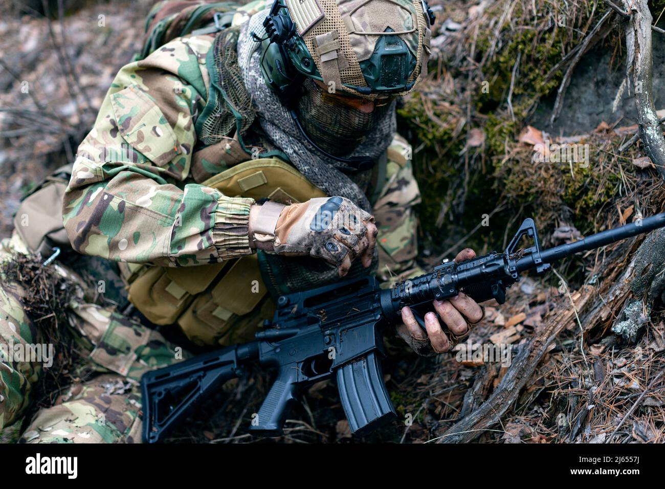 The mercenary soldier during the clash cleans the weapon from the earth ...