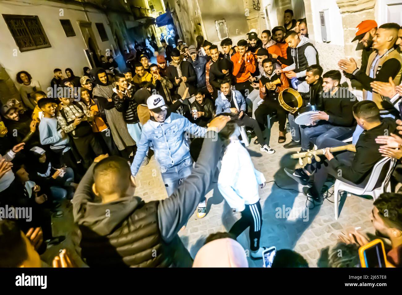 Youth prtying dancing in the streets of Medina, Essaouira, Morocco during holy month of Ramadan. Night ramadan celebration. Stock Photo