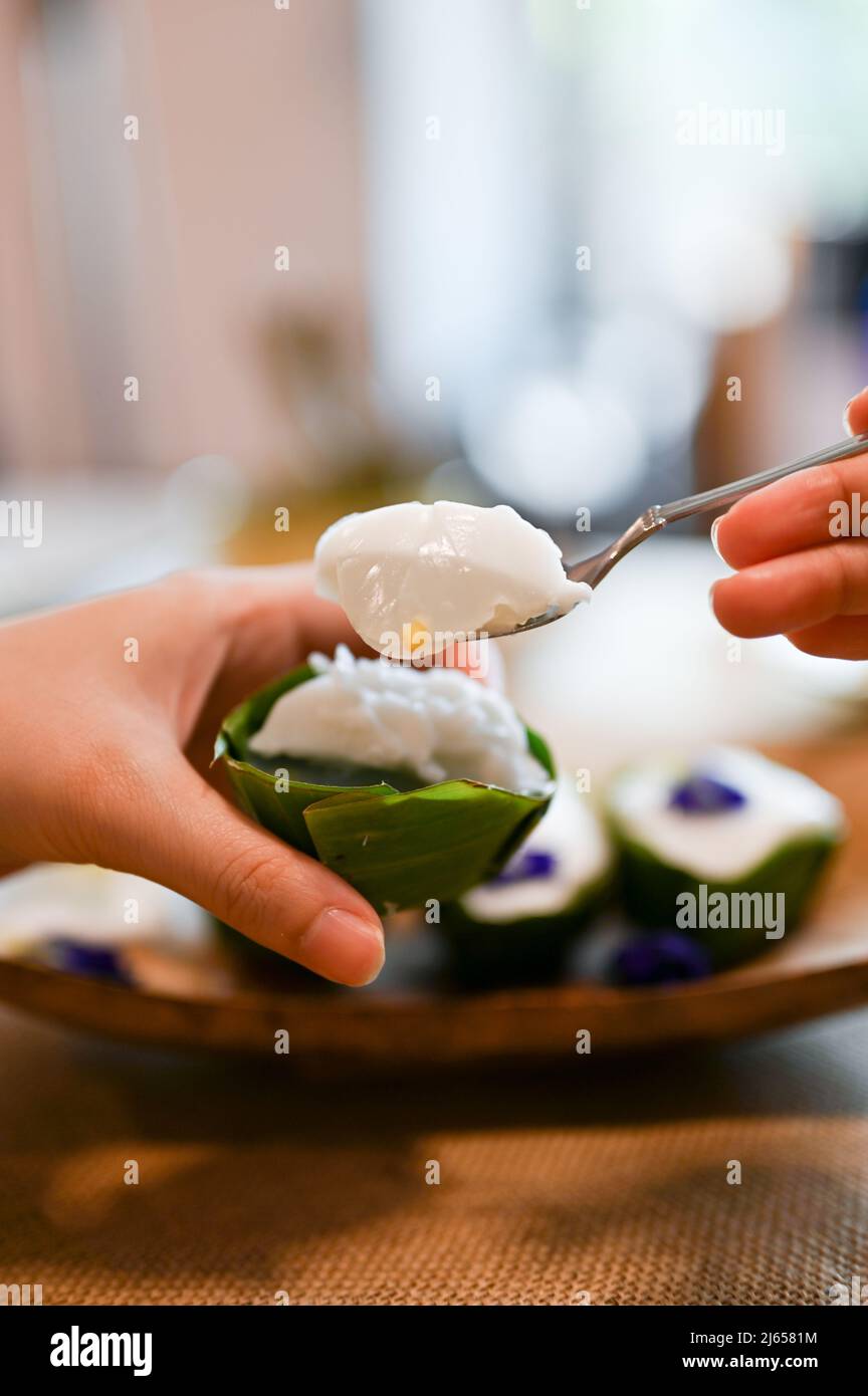 Female eating Thai coconut pudding with spoon. closeup image