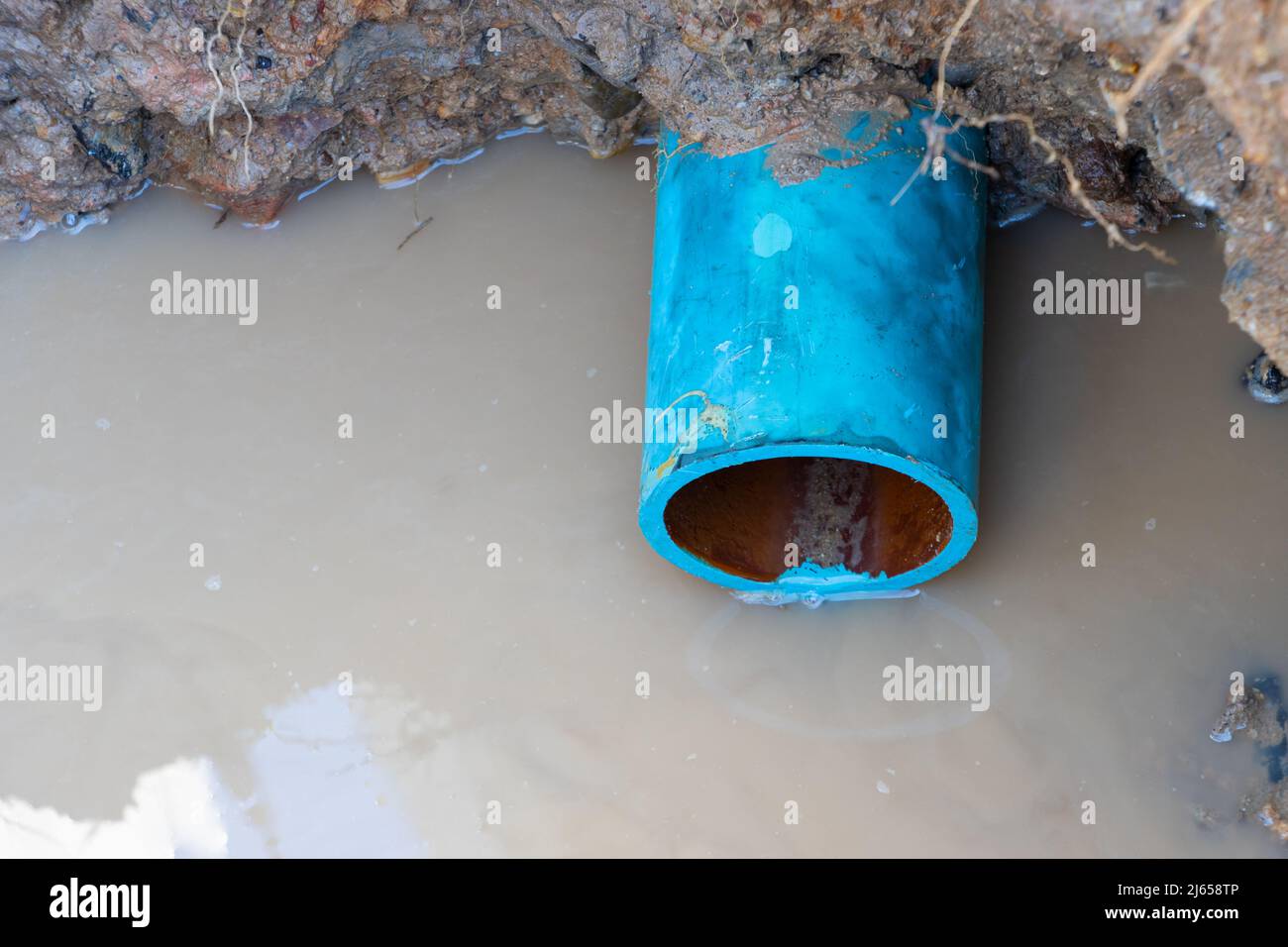 plumbing broken plastic pipe in the hole and water in wait repair Stock Photo