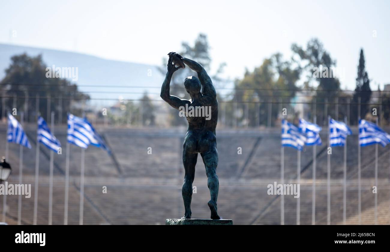 Athens, Greece. Discus thrower bronze statue, discobolus sculpture, Panathenaic Stadium blur background. Male athlete body rear view Stock Photo